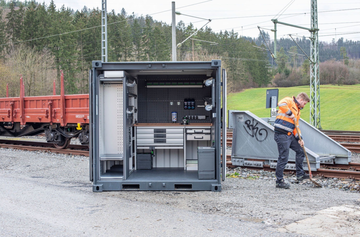 Atelier en container avec un équipement de véhicules robuste pour des projets durables dans la construction de routes, le génie civil ainsi que l'aménagement de jardins et de paysages.